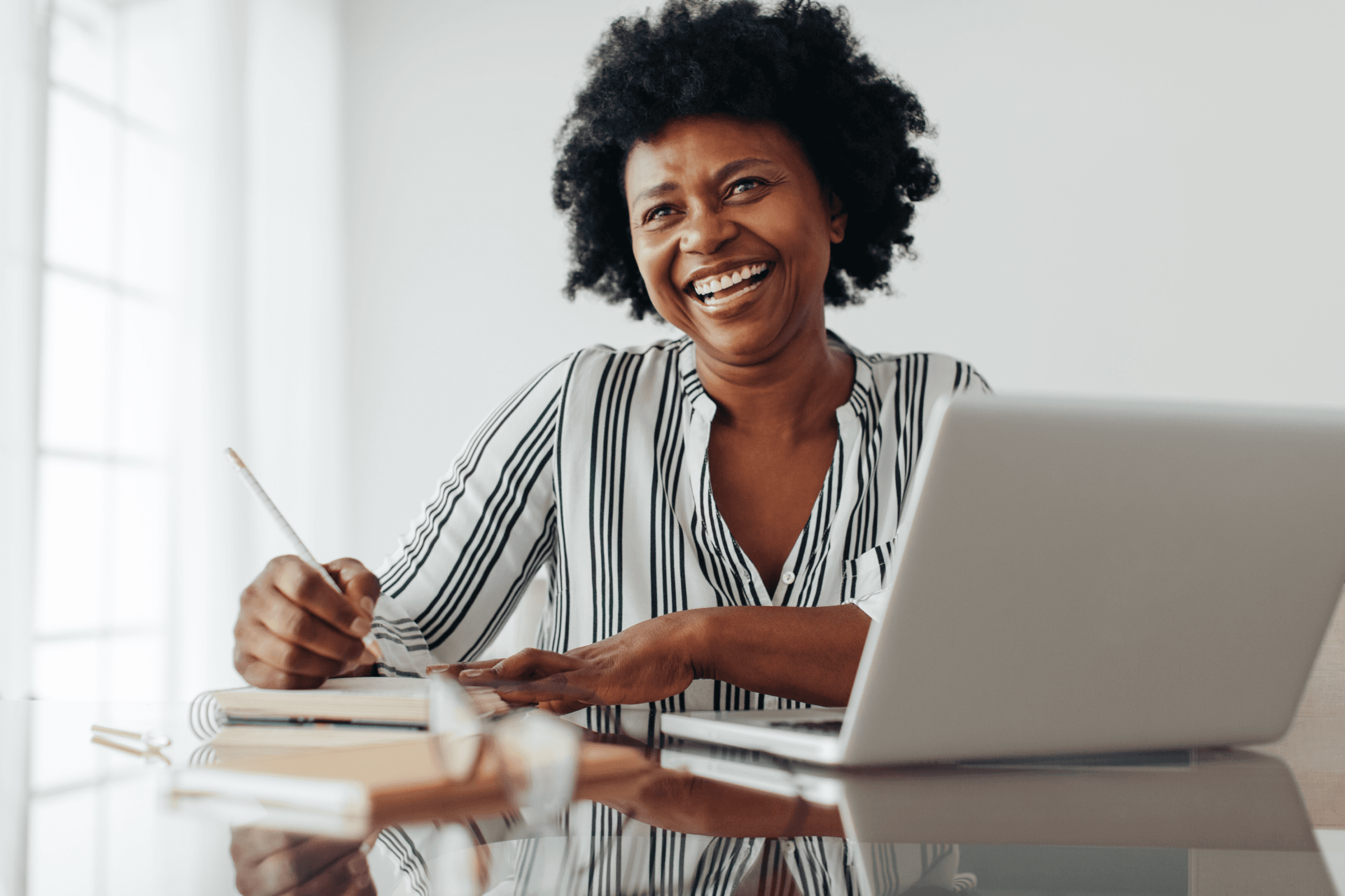 Woman smiling while working on a laptop